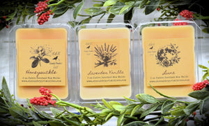 A photo showing various clamshell plastic cases with wax melt tarts inside. The cases have labels that feature a primitive sketch of each flavor or scent.