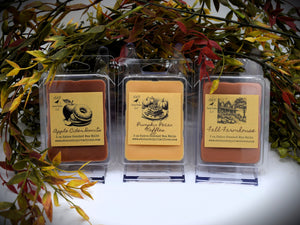 A photo showing various clamshell plastic cases with wax melt tarts inside. The cases have labels that feature a primitive sketch of each flavor or scent.